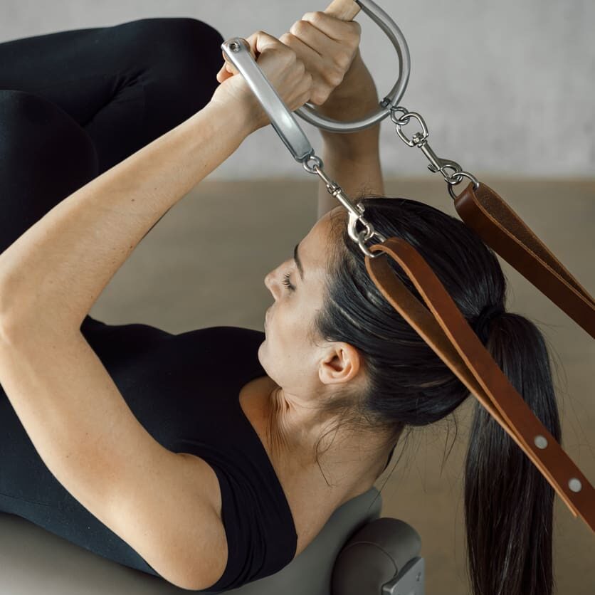 A woman is using the sling to do exercises.