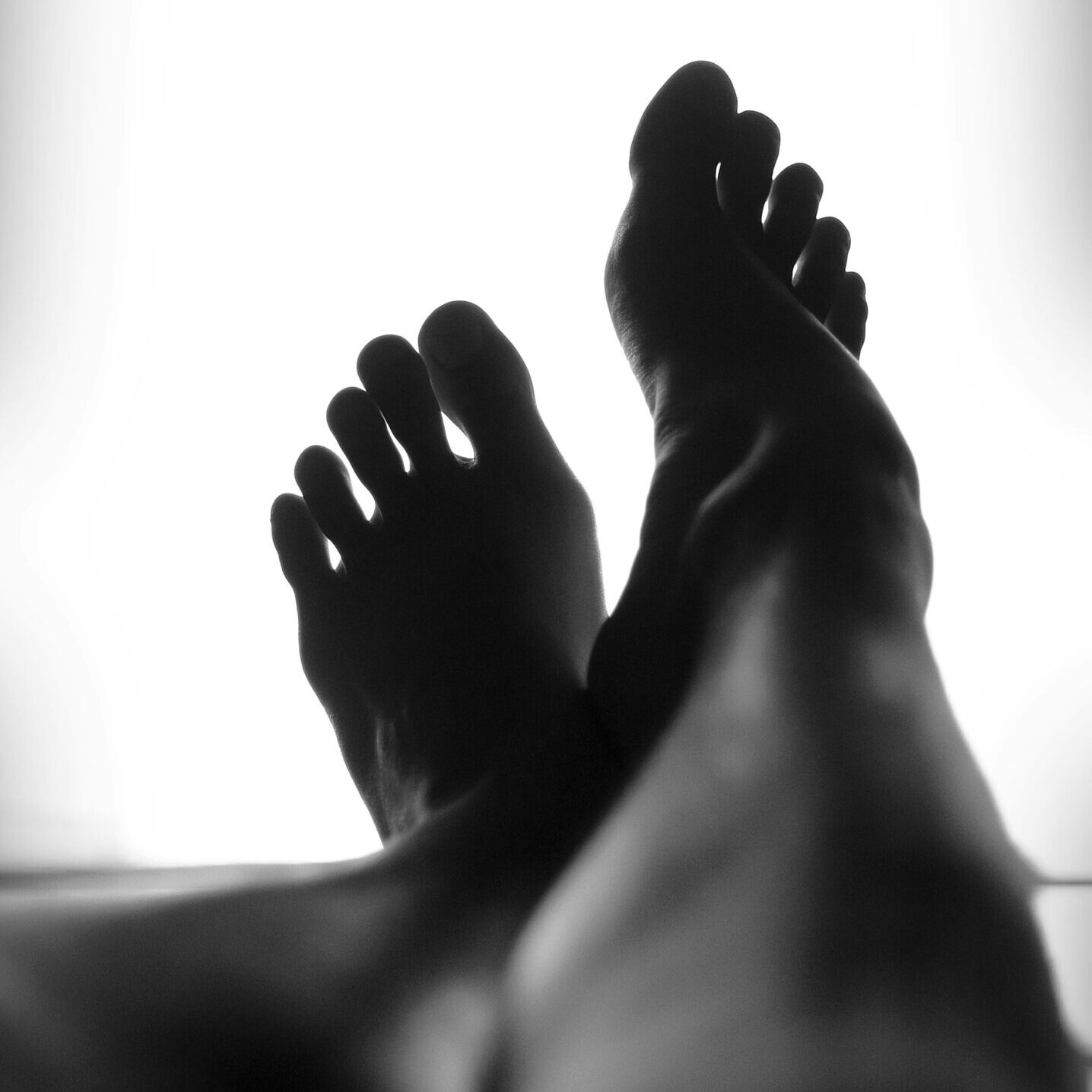 A person 's feet are shown in the sunlight.